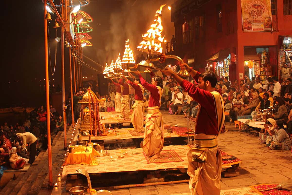Priests performing Ganga Aarti ceremony at Dashashwamedh Ghat with fire lamps and crowds of devotees watching